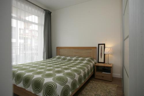 Schlafzimmer mit einem Bett und einem Fenster in der Unterkunft 365 Apartments Malūno Vilos in Palanga