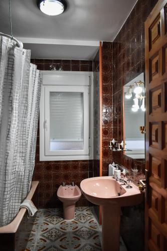 a bathroom with a sink and a toilet and a window at Mirador Alegre in El Burgo de Osma
