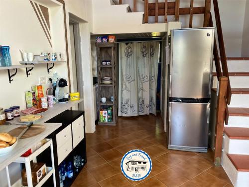 una cocina con nevera de acero inoxidable y escaleras en BnB Dog and Friend, en Rocchetta Tanaro