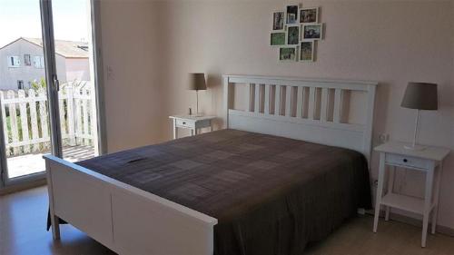 une chambre avec un grand lit et un balcon dans l'établissement Villa 8 personnes - piscine privative - Golf- Plage, à Saint-Cyprien