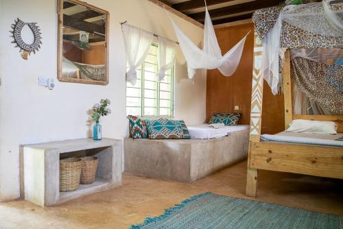 Cette chambre comprend 2 lits et une fenêtre. dans l'établissement Mawingu lodge, à Kizimkazi