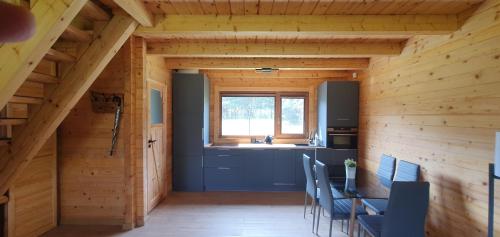 a kitchen and dining room in a log cabin at Domki z bala przy plaży Orle Jezioro Głuszyńskie in Orle