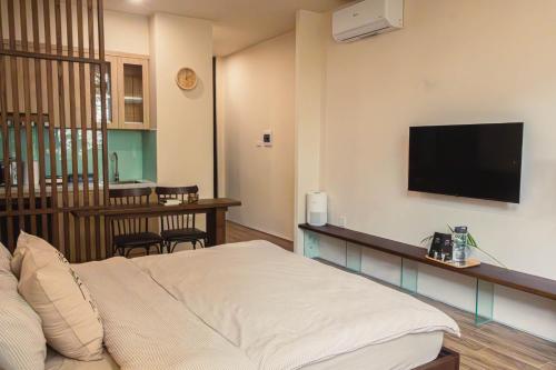 a hotel room with a bed and a flat screen tv at Areca Boutique Apartments Hanoi in Hanoi
