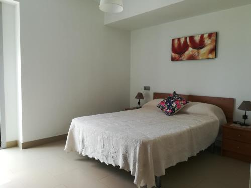 1 dormitorio con 1 cama y una pintura en la pared en Apartamento Mirador de la Cala JPC, en Benidorm