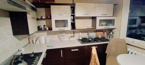 een keuken met witte kasten en een wastafel bij Apartament NG in Wieliszew