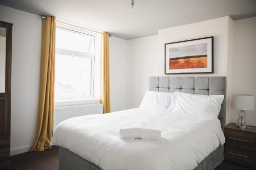 a bedroom with a large white bed with a window at Leicester Park House in Leicester