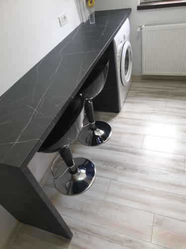 a black counter top with two bar stools under it at Bucovina Cazare in Câmpulung Moldovenesc
