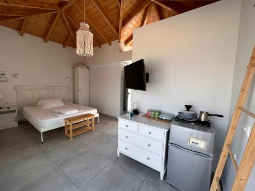 a kitchen with a refrigerator and a bed in a room at Theros - Bahia in Elafonisos