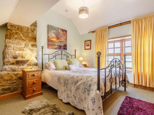 a bedroom with a bed and a stone wall at 2 Bed in Kielder 88214 in Yarrow
