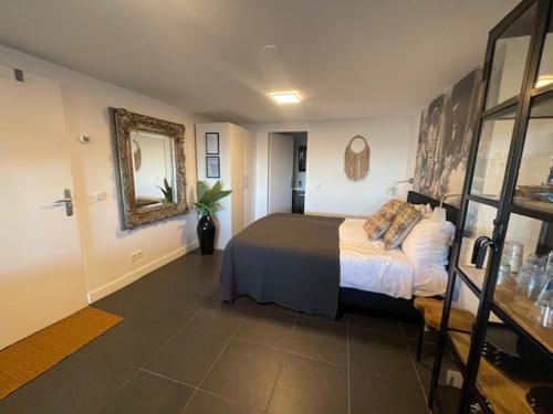 een slaapkamer met een bed en een spiegel aan de muur bij B&B Zeespiegel in Zandvoort