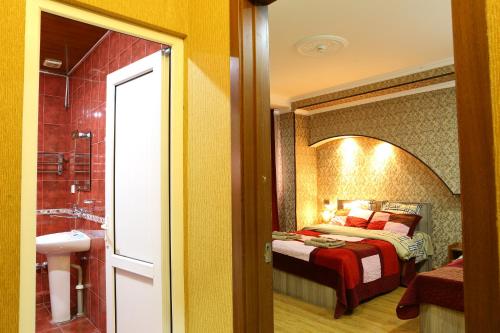 een slaapkamer met een bed en een badkamer met een douche bij Dkd-bridge Hotel in Tbilisi City