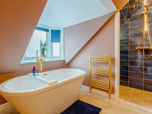 a bathroom with a large tub and a shower at 3 Bed in Lossiemouth 87871 in Lossiemouth
