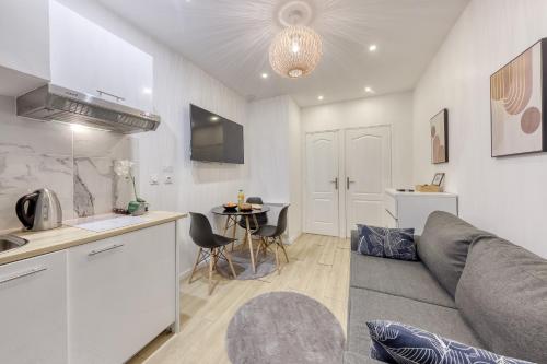 Il dispose d'une cuisine et d'un salon avec un canapé et une table. dans l'établissement Studio Parisien proche Tour Eiffel - 3 min métro, à Paris