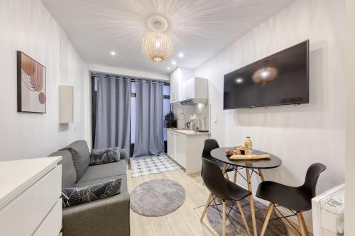 un salon avec un canapé et une table dans l'établissement Studio Parisien proche Tour Eiffel - 3 min métro, à Paris