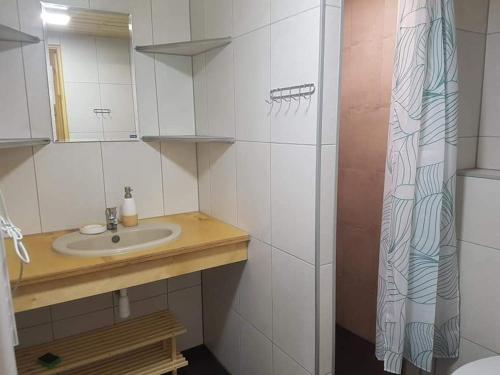 a bathroom with a sink and a shower curtain at Ośrodek Krasnal Makowo in Iława