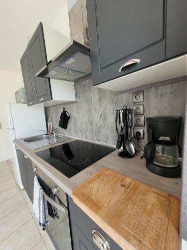 Il comprend une cuisine équipée d'un évier et d'une cafetière. dans l'établissement Charmante Maison - Evasion nature et confort, à Saint-Jean-de-Monts