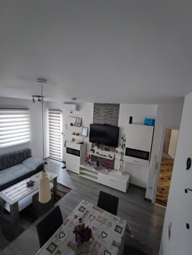 a living room with a couch and a tv at Stan na dan Apartman KRISFIL Prnjavor in Prnjavor
