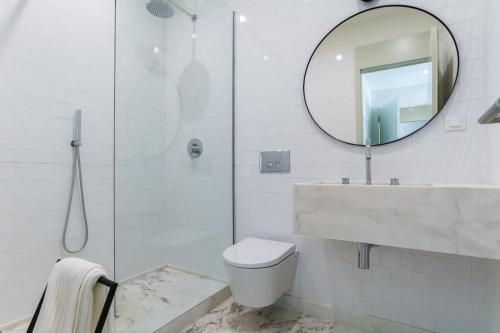 a bathroom with a sink and a toilet and a mirror at Modern & Bright Faro Mercado Apt 12 in Faro