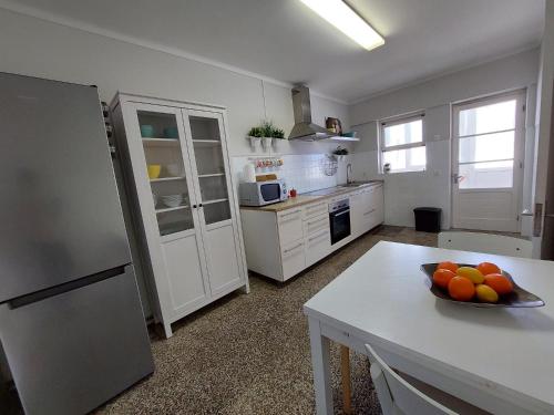 una cocina con una mesa con un bol de fruta. en Charme Apartment Center en Angra do Heroísmo