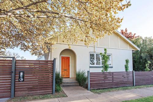 a house with a fence and a orange door at The Orange Door Mudgee -a spacious home in town in Mudgee