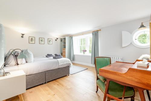 1 dormitorio con cama, escritorio y mesa en Burnside - gorgeous romantic cottage for 2 en Monzie