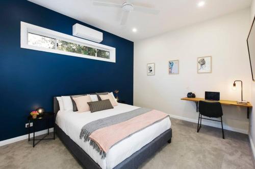a bedroom with a bed and a blue wall at The Orange Door Mudgee -a spacious home in town in Mudgee