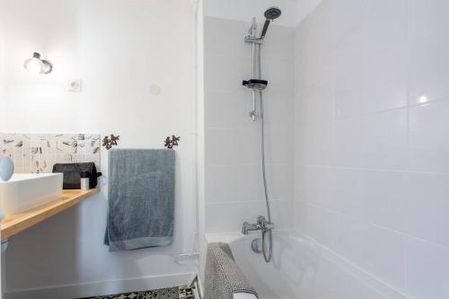 a white bathroom with a shower and a sink at Le Marais, fantastic view on Archives Nationales in Paris