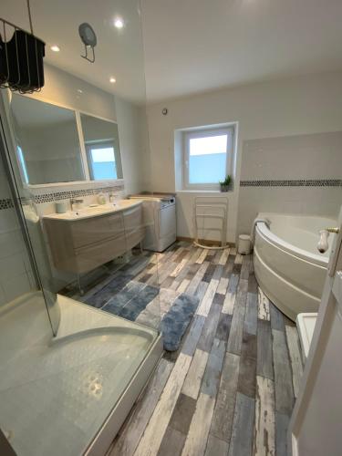 ein Badezimmer mit zwei Waschbecken, einer Badewanne und einer Badewanne in der Unterkunft Duplex à Wissant 115m2-terrasse- vrai weekend jusque 16h le dimanche in Wissant