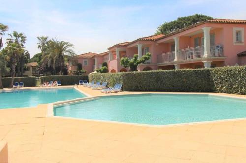 une grande piscine devant une maison dans l'établissement GRILEG- Pour des vacances idéales en famille ! T2 cabine dans résidence avec piscine chauffée, à Grimaud