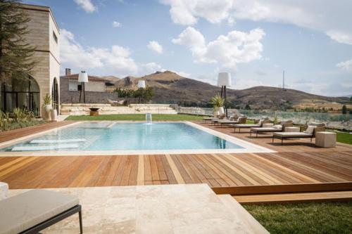 uma piscina num quintal com cadeiras e um edifício em Villa Boutique Cappadocia em Ürgüp