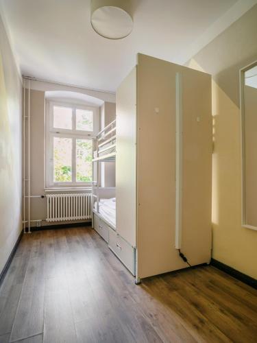 an empty room with a bed and a window at EastSeven Berlin Hostel in Berlin