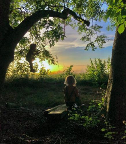 een klein meisje op een bank onder een boom bij Farsk Britswert 