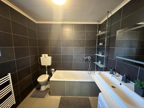 ein Badezimmer mit einer Badewanne, einem WC und einem Waschbecken in der Unterkunft city apartment in Graz
