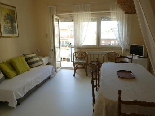 una camera con due letti, un divano e una finestra di Luminoso Appartamento A 80 Metri dal Mare a Terracina