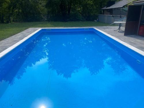 una piscina azul con reflejo en el agua en Villa Ruzmarin, en Zolaći