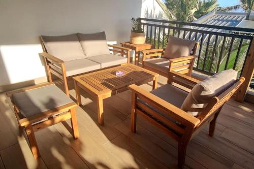 a balcony with chairs and a couch and a table at Les lataniers 2 - Vue sur mer in Saint-Pierre