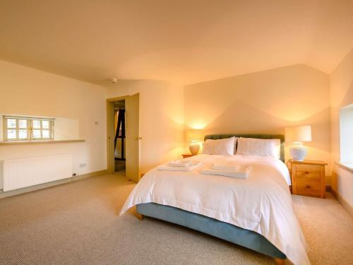 um quarto com uma cama grande e lençóis brancos em 3 Bed in Buttermere 88773 em Buttermere