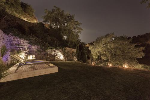 a park bench sitting in the grass at night at Locanda Don Serafino Historical Boutique Hotel in Ragusa