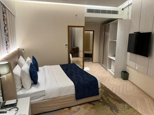 Habitación de hotel con cama y TV en Chinmay Hotel & Resort, en Lucknow