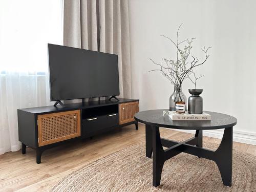 a living room with a tv and a coffee table at 2-BR Flat with Style and Comfort in St John’s Wood in London