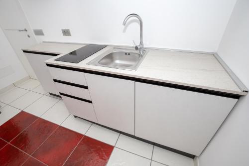 una cucina con lavandino e armadietti bianchi di Terramare a Maiori