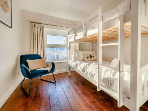 a bedroom with two bunk beds and a blue chair at 5 Bed in Bassenthwaite 89496 in Torpenhow