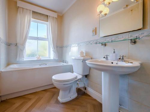 a bathroom with a toilet and a sink and a tub at 3 Bed in Cockermouth 89139 in Aspatria
