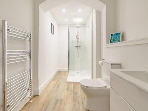 La salle de bains blanche est pourvue d'une douche et de toilettes. dans l'établissement 6 Bed in St Andrews 89572, à Leuchars