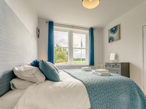 a bedroom with a large bed with a window at 6 Bed in St Andrews 89572 in Leuchars