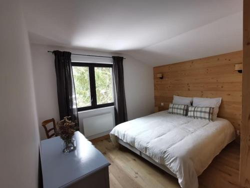 une chambre avec un grand lit et une fenêtre dans l'établissement Appartement 120m2 pour 10 La Giettaz Le Plan, à La Giettaz
