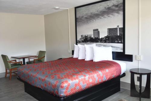 a hotel room with a large bed with white pillows at Super 8 by Wyndham Biloxi in Biloxi