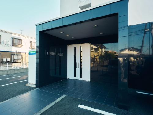a black and white building with a white door at intro vetta 1001 Free parking in Kumamoto