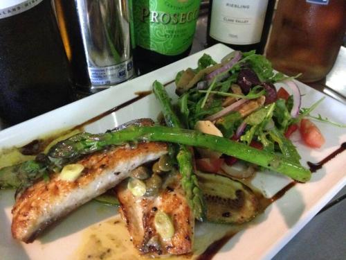 a plate of food with fish and a salad at Absolute beachfront apartment in Trinity Beach