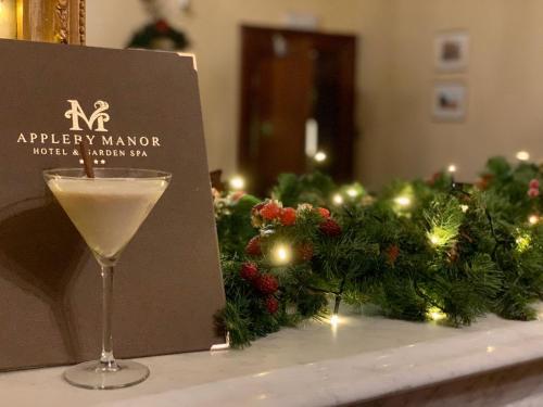 a martini glass sitting on a table with christmas decorations at Appleby Manor Hotel & Garden Spa in Appleby